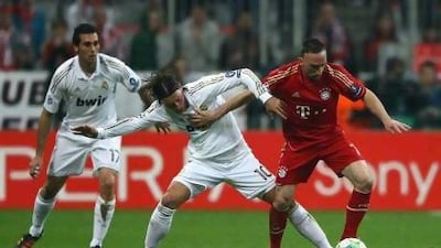 Real Madrid's Mesut Oezil, centre,challenges Bayern Munich's Franck Ribery in the first-leg of their Uefa Champions League semi-final.