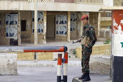 A Syrian soldier stands guard outside the Beirut headquarters of the Syrian army intelligence. AFP