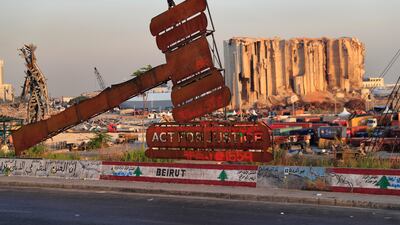 A monument that represents justice stands in front of towering grain silos that were gutted in the massive August 2020 explosion at the port that killed more than 200 people in Beirut. AP Photo