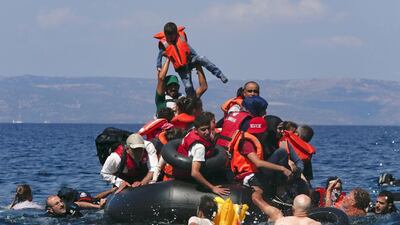 A refugee raises a child into the air among Syrian and Afghan migrants after their boat deflated before reaching the Greek island of Lesbos in September 2015. Reuters
