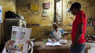 Kamaal speaks with a customer at his building materials shop during Ramadan.
