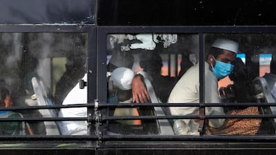 Men wearing protective masks sit inside a bus that will take them to a quarantine facility, amid concerns about the spread of coronavirus disease (COVID-19), in Nizamuddin area of New Delhi, India. REUTERS