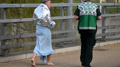 A member of the emergency services speaks to a man who was forced to leave the swimming pool suddenly. Getty Images