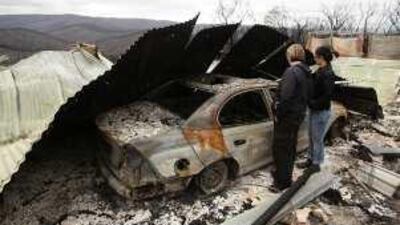 Kylie Gill and Lisa Clemance inspect the remains of their property at Steels Creek near Melbourne.