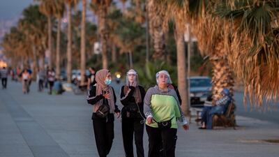 People walk the promenade during a sunset along the Corniche Al Bahr just before the start of nightly restrictions, in Beirut, Lebanon. EPA