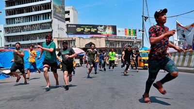Anti-government protesters run for cover during skirmishes with shop owners near Baghdad’s Tahrir Square Tuesday, April 21, 2020. AP