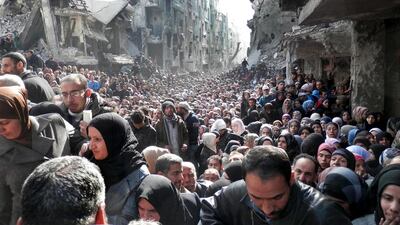 File photo released by the United Nations Relief and Works Agency for Palestine Refugees in the Near East (UNRWA) shows residents of the besieged Palestinian camp of Yarmouk, queuing to receive food supplies, in Damascus, Syria. There are reports the camp has fallen into the hands of ISIL. UNRWA/AP Photo