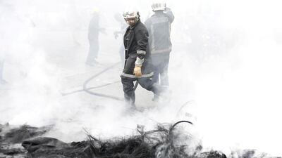Firefighters walk among white smoke after extinguishing a burning barricade made out of tyres, during protests demanding Haiti's President Jovenel Moise to step down, in Port-au-Prince, Haiti. Reuters