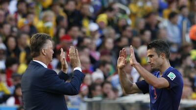 Netherlands coach Louis van Gaal, left, high-fives Robin van Persie during their 3-2 win over Australia on Wednesday at the 2014 World Cup. Edgard Garrido / Reuters
