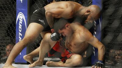 Demetrious Johnson, top, wrestles with Chris Cariaso during his successful flyweight title defence on Saturday night in Las Vegas. John Ocher / AP / September 27, 2014