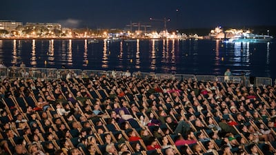 Spectators watch The Way of the Dragon at the Cinema de la plage at the 76th edition of the Cannes Film Festival. AFP