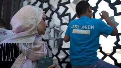 Scores of desperate Palestinians and holders of other passports, including Egyptians, wait at the gates of Gaza's southern Rafah Crossing into Egypt. Cairo is allowing only a trickle of people to leave the blockaded territory. Heidi Levine for The National