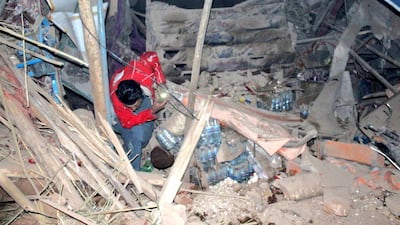A rescue worker sifts through the rubble of fallen debris. Reuters
