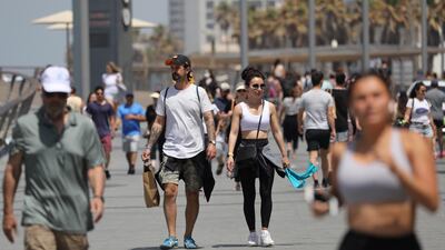 People without face masks enjoy the weather on the beach of Tel Aviv. EPA
