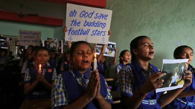 Schoolchildren pray for the schoolboys who are trapped inside a flooded cave in Thailand's northern province of Chiang Rai, at a school in Ahmedabad, India. Reuters
