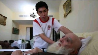 Jeruy Greg working as a nurse helping Mohammed Kazim Habib at his home in Ajman.