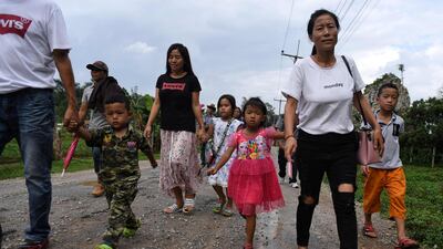 This picture taken shows visitors walking up the road leading to the Tham Luang cave, in which 12 boys from the "Wild Boars" football team and their coach were trapped last year. AFP