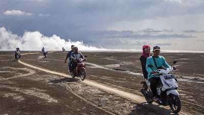 Visitors ride motorcycles over the mudflow during the tenth anniversary of the eruption. Ulet Ifansasti / Getty Images