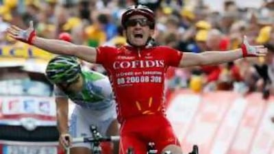 Samuel Dumoulin of France throws up his arms in delight after winning the third stage.