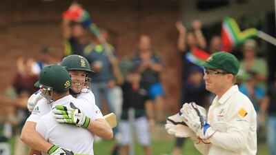 South Africa's batsman AB de Villiers, left facing camera, is embraced by teammate JP Duminy, front left, after reaching his century as Australia's wicketkeeper Brad Haddin, right, applauds on the second day of their second Test match against Australia at St George's Park in Port Elizabeth, South Africa, on February 21, 2014. Themba Hadebe / AP Photo