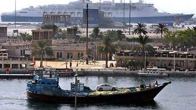 A dhow sails on Dubai creek as it passes the QE2 docked at Port Rashid in Dubai in 2009. AP Photo