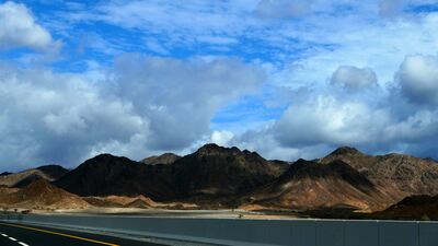 Clouds pass over the tips of mountains in the Northern Emirates.