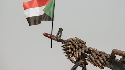 A Sudanese flag placed above the muzzle of a machine gun covered with an ammunition belt of the Rapid Support Forces (RSF) paramilitaries before a rally for supporters of Sudan's ruling Transitional Military Council (TMC) in the village of Abraq, about 60km northwest of Khartoum. AFP