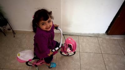 Leen Omar plays in her home last week. Her mother cannot obtain identity and residency documents for her because her father left the country.