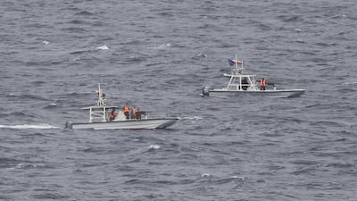 Members of Iran's Revolutionary Guard watch the USS George HW Bush from their armed vessels as the aircraft carrier travels through the Strait of Hormuz on March 21, 2017. Jon Gambrell / AP Photo