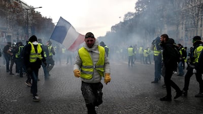 A demonstrator wearing a yellow vest grimaces through tear gas in Paris. AP Photo
