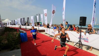 Children in the under 13 category race to the finish line at the Corniche in Abu Dhabi. Ravindranath K / The National