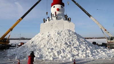 Cranes are seen next to workers sculpting a giant snowman by the Songhua River in Harbin, Heilongjiang province, China. Reuters