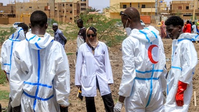 Members of the Sudanese Red Crescent and forensic experts exhume bodies from makeshift graves for reburial in Khartoum's suburb of Al Azhari. AFP