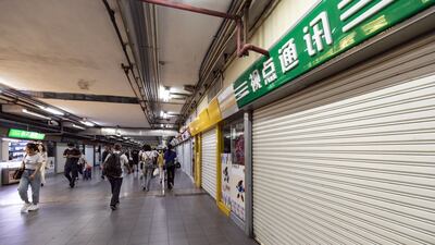 Pedestrians pass shuttered stores in an underground passageway under the Shanghai Railway Station in Shanghai, China. Bloomberg