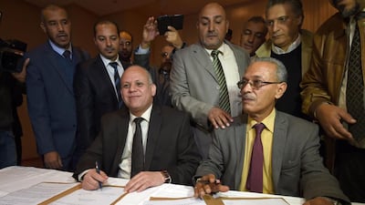 Awad Mohammed Abdul Sadiq, the first deputy head of the Tripoli-based General National Congress (GNC), and Ibrahim Fethi Amish from the internationally recognised House of Representatives, sign documents after reaching an agreement on ending the political deadlock in Libya following a meeting in the Tunisian town of Gammarth on December 6. AFP Photo
