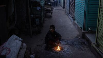 A boy warms himself by a fire at a market in Delhi. Reuters