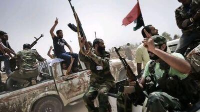 Libyan rebel fighters shoot in the air and shout religious slogans as they attend the funeral of seven fallen comrades killed the day before during the battle for the control of Brega, at the main cemetery in Benghazi yesterday. Gianluigi Guercia / AFP Photo