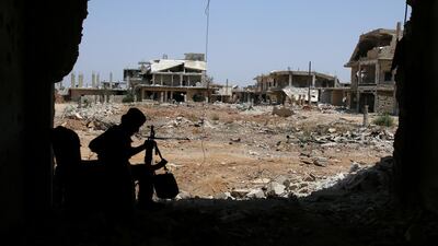 A Free Syrian Army fighter sits with his weapon in Al Manshiyeh neighbourhood in Deraa. Alaa Al Faqir / Reuters