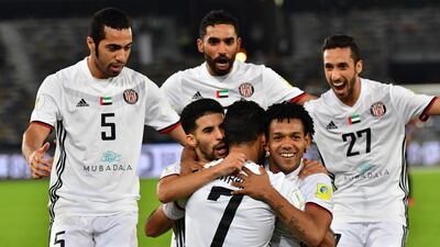 Al Jazira's Brazillian Romarinho, centre right, hugs goalscorer Ali Mabkhout after the Emirati's goal against Urawa Red Diamonds set up a Fifa Club World Cup semi-final against Real Madrid. Giuseppe Cacace / AFP