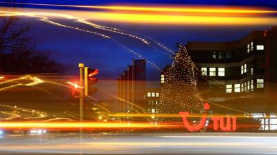Cars drive past an illuminated logo of German travel and tourism giant TUI at the company's headquarters in Hanover, central Germany, on December 9, 2014. TUI presented its annual business report for 2013/14 on December 10, 2014. JULIAN STRATENSCHULTE / AFP