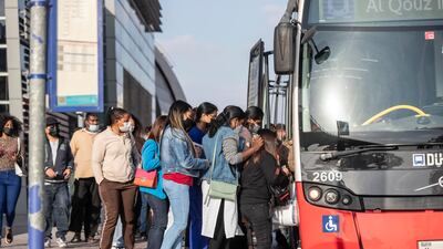 Commuters wearing masks queue at the Al Safa Metro station to get on a Dubai Bus. Antonie Robertson / The National