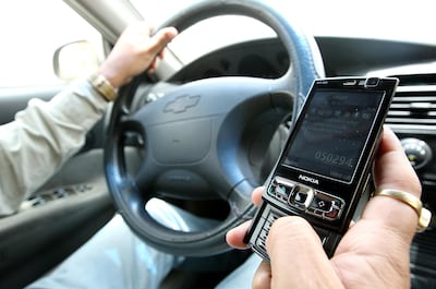 Both men and women are guilty of using phones while in the driver's seat. Pawan Singh / The National