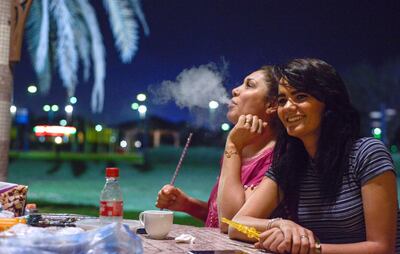 Olfa Baraker, 37, and Abir Abidi, 26, enjoy shisha at Family Park, opposite the Corniche, early on Sunday morning. Khushnum Bhandari / The National