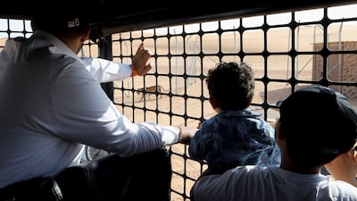 A family watches from inside a vehicle as a tiger prowls through the Riyadh Safari area.