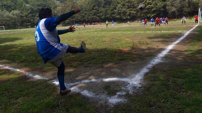 People play football on a field at the Teoca volcano crater. AFP
