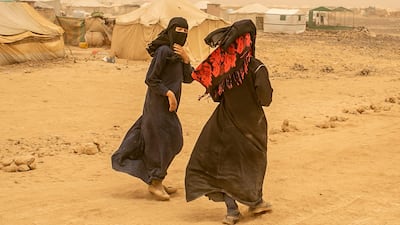 Hayat, 14, the daughter of a member of the pro-government forces walks with her cousin around tents at a new displacement camp in Marib province. Asmaa Waguih for The National