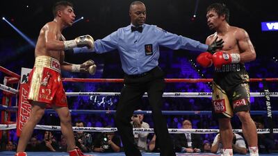 Jessie Vargas, left, and Manny Pacquiao are separated by referee Kenny Bayless. Christian Petersen / Getty Images