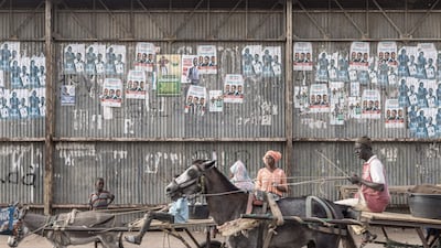 Carts pass electoral posters in Dhara, as 18 men and one woman compete to become Senegal's fifth president. AFP
