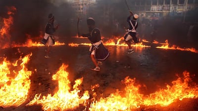 Sikh devotees, show their skills depicting a mock fight in a ring of fire, as they perform during a religious procession to mark the 350th birth anniversary of Guru Gobind Singh, the tenth Sikh guru in Bhopal. Sanjeev Gupta / EPA