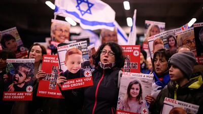 Protesters holding images of children believed to be hostages in Gaza attend a rally outside the Red Cross's London offices. Getty Images